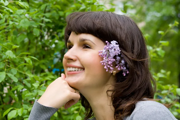 Beautiful girl, in her hair lilac, in nature — Stock Photo, Image