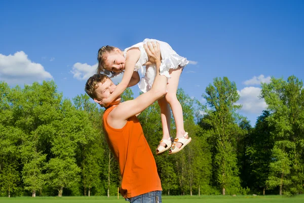 Father raise daughter on hands, in nature — Stock Photo, Image