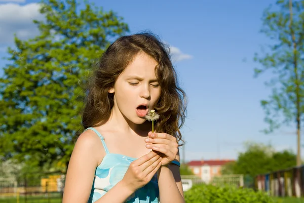 Девушка дует на одуванчик, в природе — стоковое фото