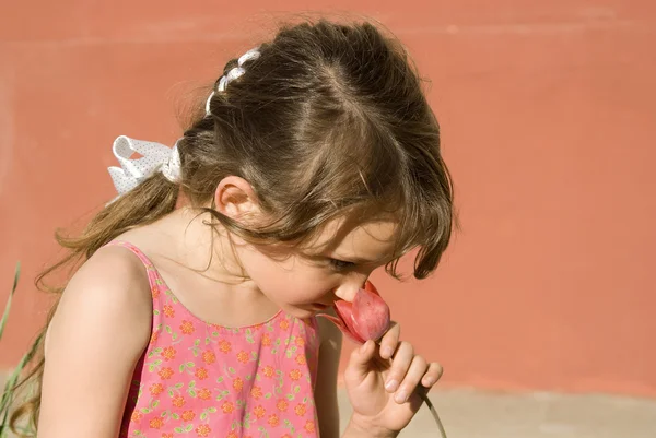 Dívka čichání Tulipán, v přírodě — Stock fotografie