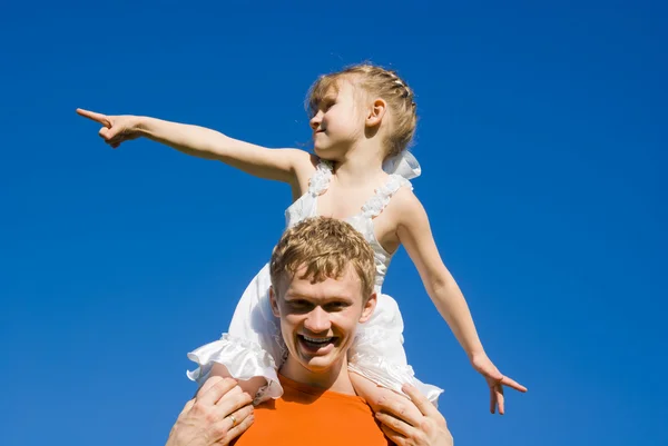 Der Vater hält die Tochter auf seinen Schultern und zeigt — Stockfoto