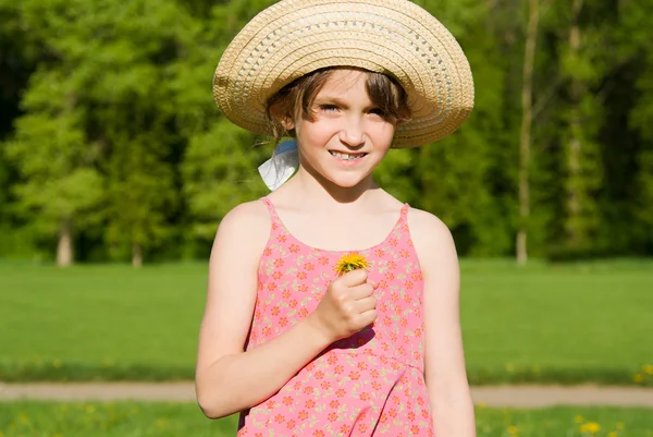 一顶帽子，拿一朵花，在自然中的女孩 — 图库照片