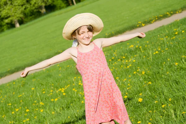 A menina de chapéu segurando uma flor, na natureza — Fotografia de Stock