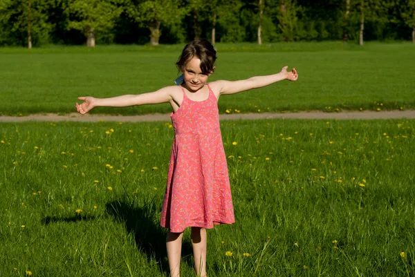 A menina está acenando com as mãos, na natureza — Fotografia de Stock