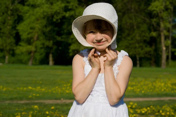 A menina no prado, segura o chapéu — Fotografia de Stock