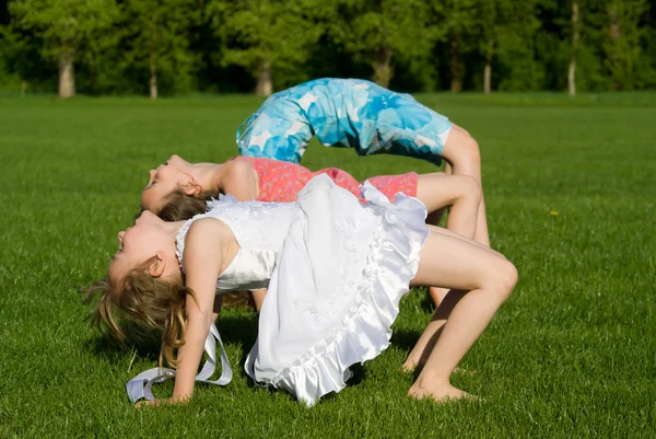Three girls doing exercises, in nature — Stock Photo, Image
