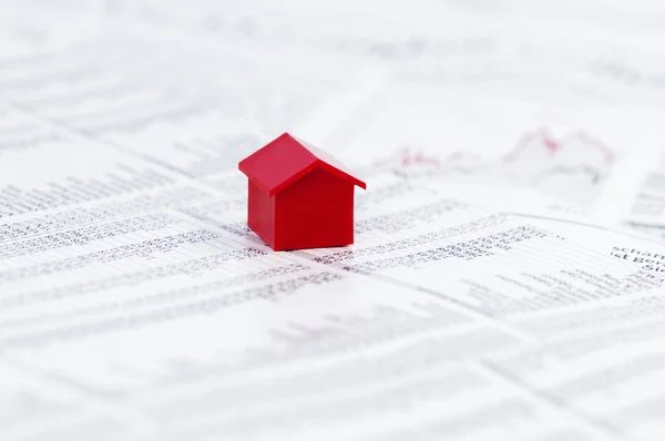Page of stock market prices with red model house — Stock Photo, Image