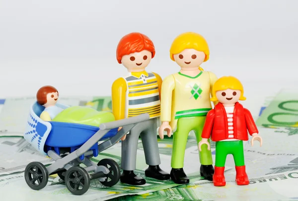 Допомога на дитину - Playmobil сім'ї та банкноти 100 євро — стокове фото
