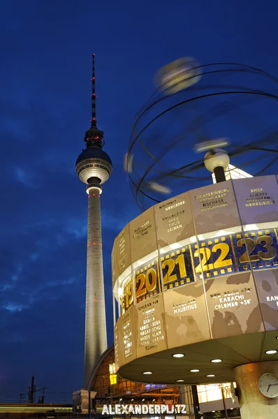 Reloj mundial con la torre de televisión por la noche — Foto de Stock