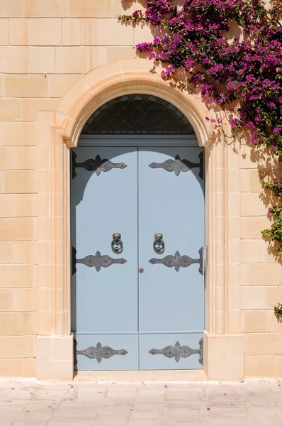 Máltai ház virágok és díszes kék ajtó — Stock Fotó