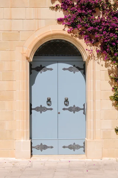 Stock image Maltese house with flowers and ornate blue door