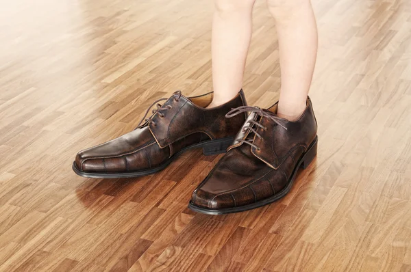 Maluch sobie obuwie dla dorosłych — Zdjęcie stockowe