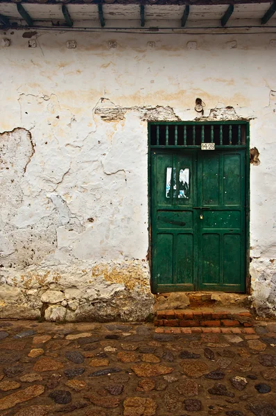 Antigua pared colonial con una puerta verde — Foto de Stock