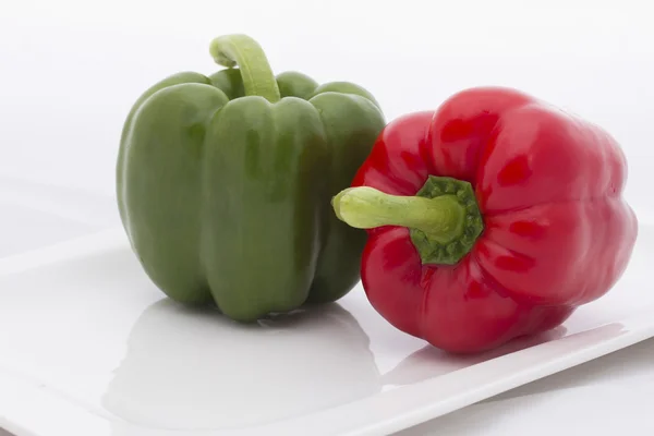 Groene en rode paprika op de witte bowl — Stockfoto
