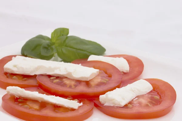Salat af tomater, ost og basilikum. Vandret . - Stock-foto