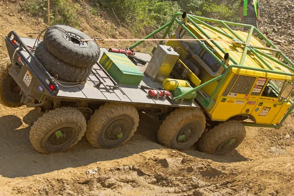 Gele vrachtwagen op moeilijk begaanbaar terrein — Stockfoto