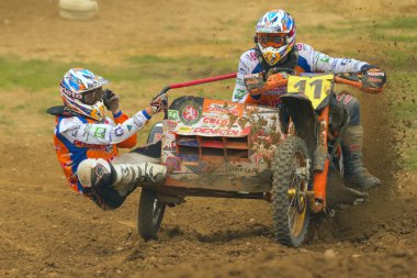 sırayla Sidecar biniciler. Motosiklet çamur uçar.