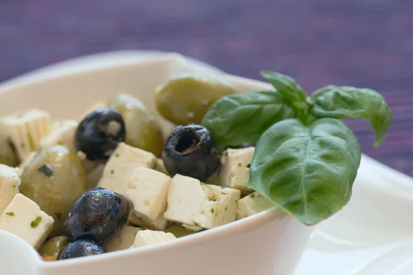 Salada de azeitonas pretas e verdes com pedaços de queijo . — Fotografia de Stock
