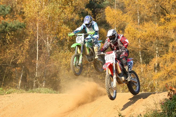 Two motocross riders in jump — Stock Photo, Image