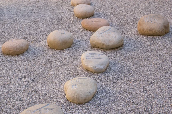 stock image Boulders carved with Chinese characters l form a cross.