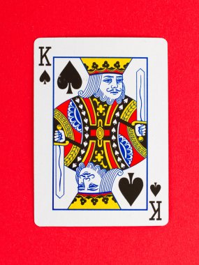 Old playing card (king) isolated on a red background clipart