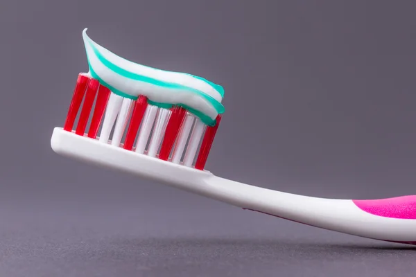 Sebuah sikat gigi merah muda dengan pasta gigi — Stok Foto