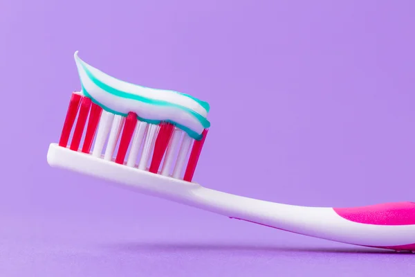 Een roze tandenborstel met tandpasta — Stockfoto