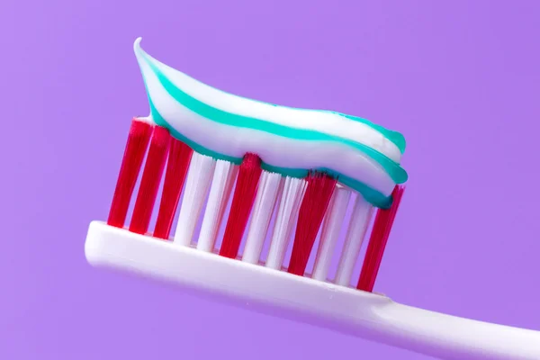 Розовая зубная щетка с зубной пастой — стоковое фото