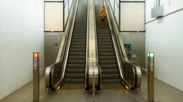 Eine junge Frau auf einer Rolltreppe — Stockfoto