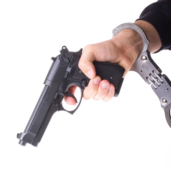Pistol in hand with handcuffs — Stock Photo, Image