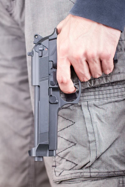 銃に焦点を当てるカジュアルな服銃を持つ男 — ストック写真
