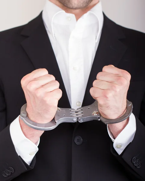 stock image Man with handcuffs, business suit, focus on the handcuffs