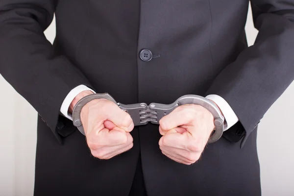 Man with handcuffs, business suit, focus on the handcuffs — Stock Photo, Image