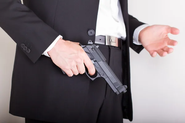 Hombre con pistola, traje de negocios, concéntrate en el arma. — Foto de Stock