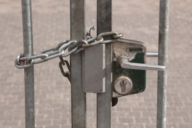 A chain hanging on a abandoned gate clipart