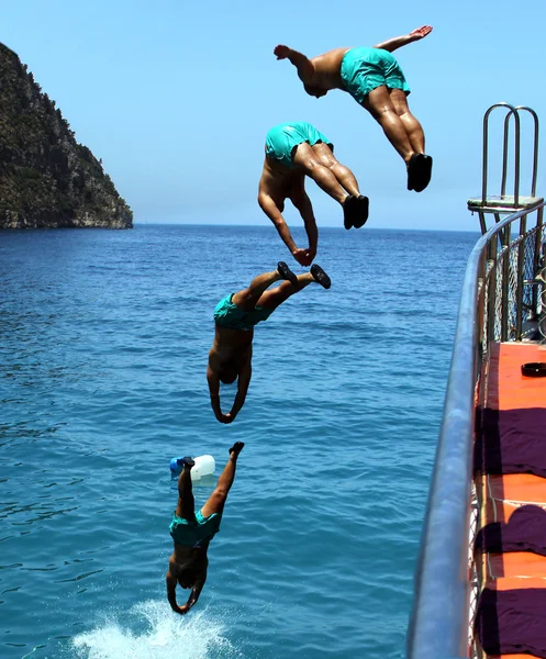 Человек прыгает в море Стоковое Фото