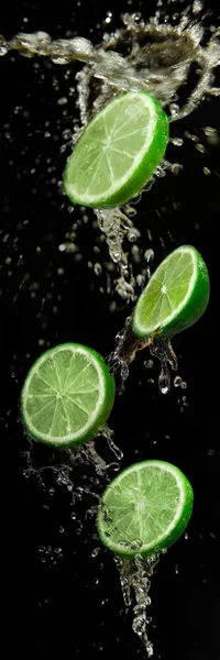 Limetten mit Wasserspritzer — Stockfoto