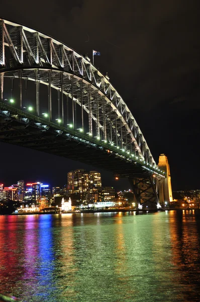 Luces del distrito financiero central de Sydney reflejadas bajo el puente del puerto de Sydney —  Fotos de Stock