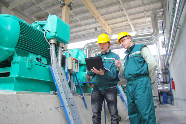 Industrial workers with notebook, teamwork