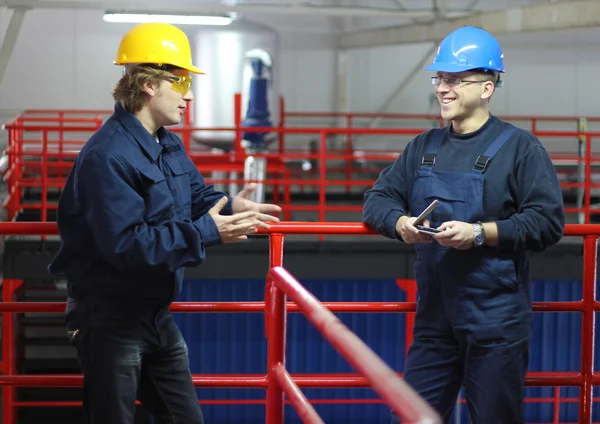 Twee werknemers praten in een fabriek — Stockfoto