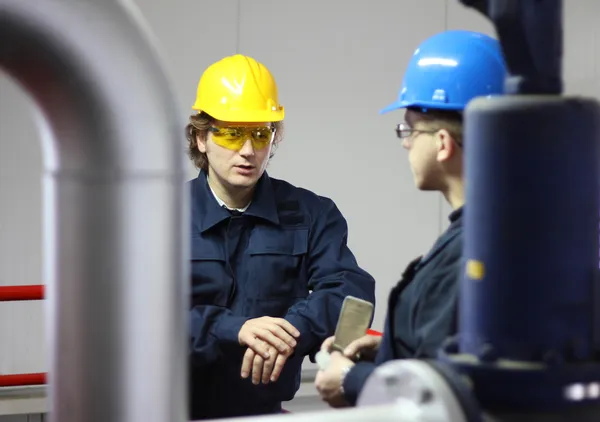 Dois trabalhadores conversando em uma fábrica — Fotografia de Stock