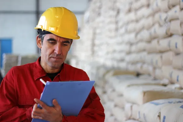 Worker writing results in factory — Stock Photo, Image