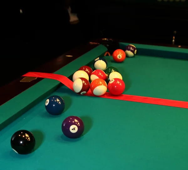 Tavolo da biliardo e palline con nastro rosso — Foto Stock