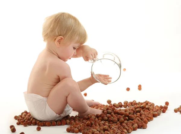Baby playing with hazelnuts — Stock Photo, Image