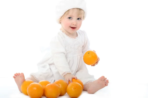 Uśmiechający się boso dziecko z pomarańczy — Zdjęcie stockowe