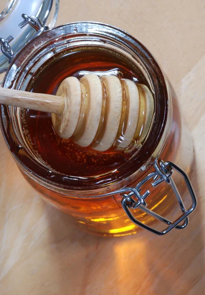 蜂蜜の瓶で棒をかき混ぜる — ストック写真