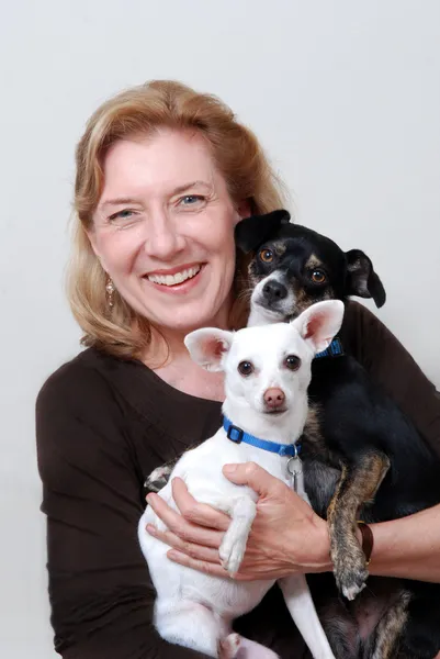 Mulher segurando 2 cães pequenos — Fotografia de Stock