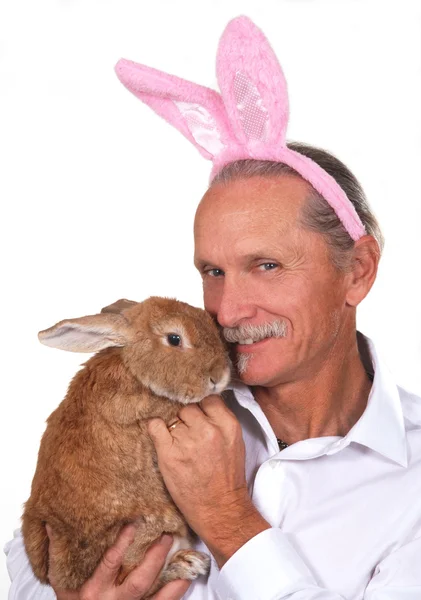 ピンクのウサギの耳を着て、ウサギを持って男 — ストック写真