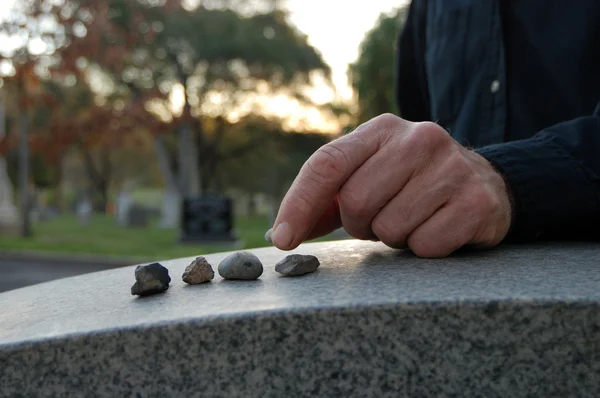 Leaving pebbles on headstone — Stock Photo, Image