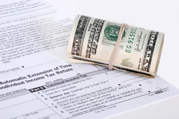 Un rollo de USD en efectivo cerca de un formulario de impuestos del IRS — Foto de Stock